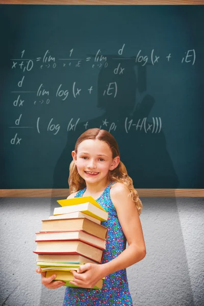 Meisje uitvoering boeken in bibliotheek — Stockfoto