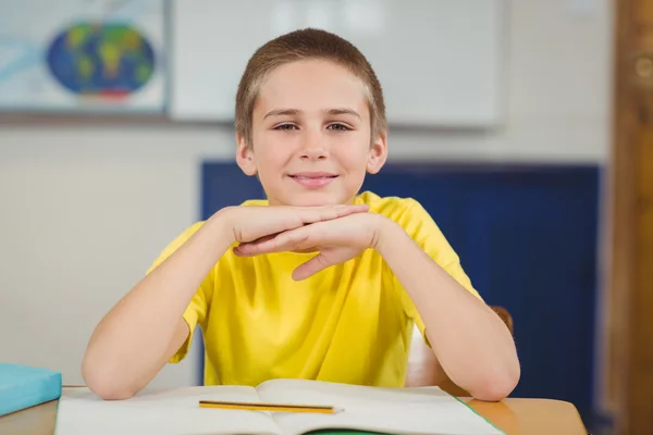 Aluno sorridente sentado em sua mesa — Fotografia de Stock