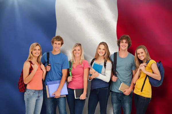 Smiling students wearing backpacks and holding books — Stock Photo, Image