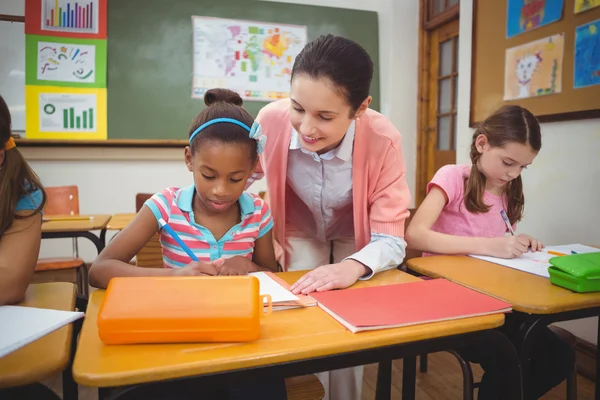 Pupil and teacher at desk in classroom — Stock Photo, Image