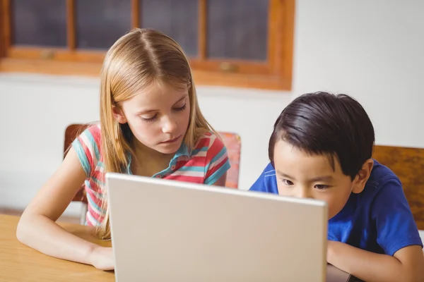 Söta elever i klass med laptop — Stockfoto