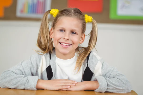 Ładny źrenica siedzi przy biurku w klasie — Zdjęcie stockowe