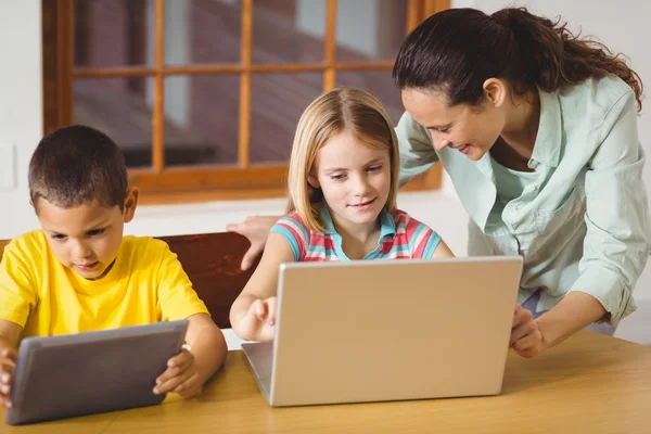 Alunos usando laptop e tablet com professor — Fotografia de Stock