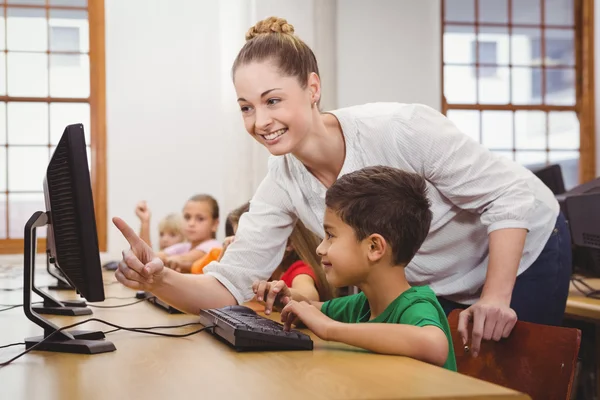 Leraar helpen een student met behulp van een computer — Stockfoto