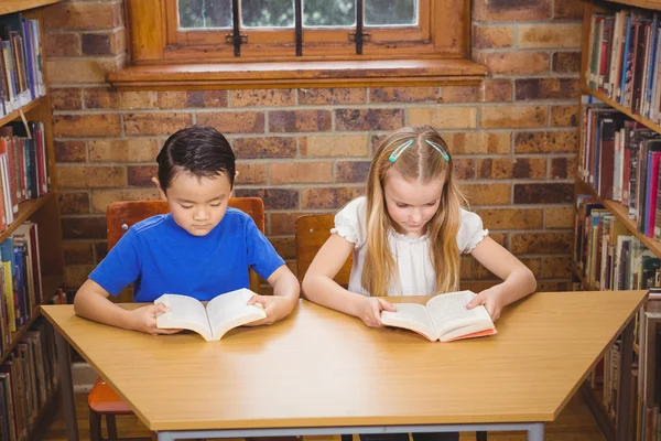 Estudiantes leyendo libros mientras se sientan — Foto de Stock