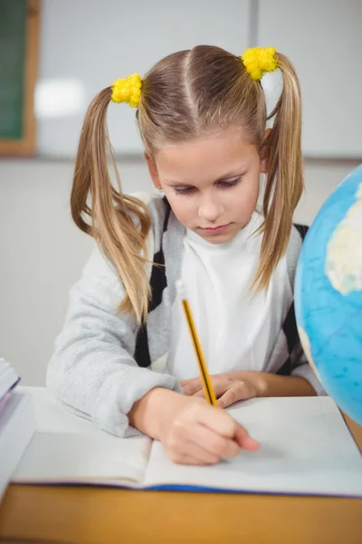 Cute uczennica pracuje przy biurku — Zdjęcie stockowe