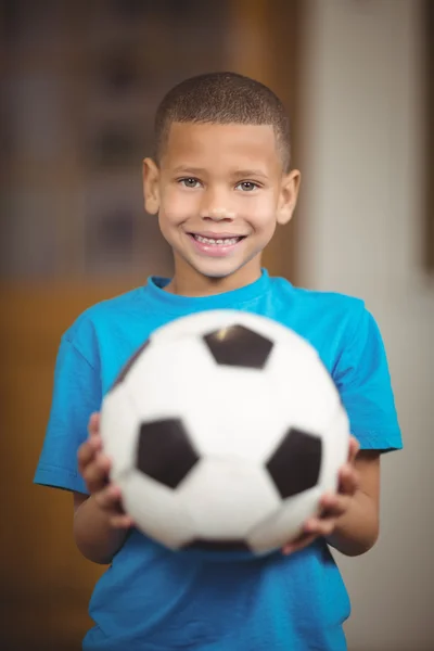 Pupil holding football in school — Stock Photo, Image