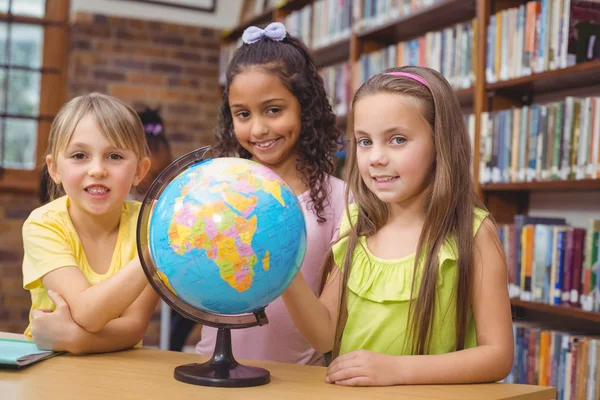 Pupilas na biblioteca com globo — Fotografia de Stock