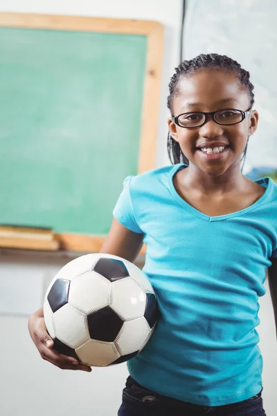 Lachende leerling houden voetbal in klas — Stockfoto