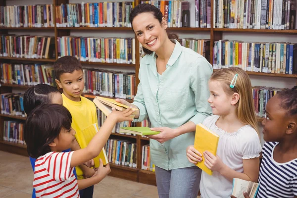 Leerlingen en leraar in de bibliotheek — Stockfoto