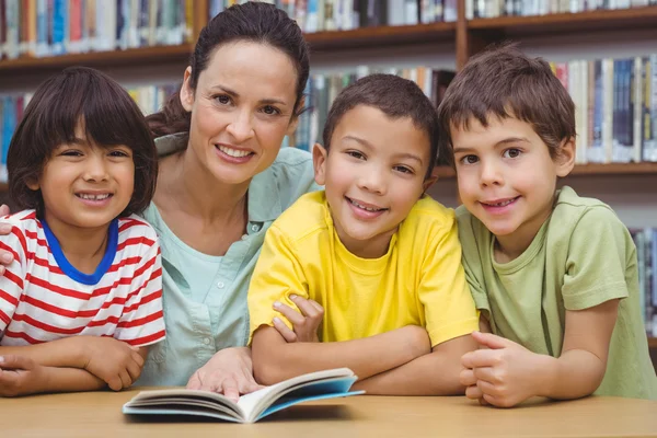 Pupils and teacher reading book — Stock Photo, Image