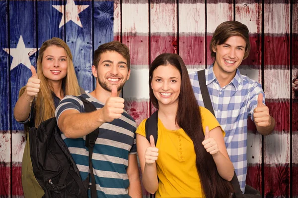 Estudantes felizes gesticulando polegares na faculdade — Fotografia de Stock