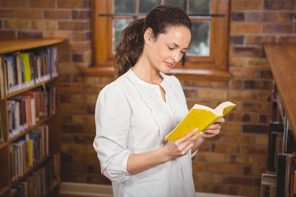 Gülümseyen öğretmen bir kitap okuma — Stok fotoğraf