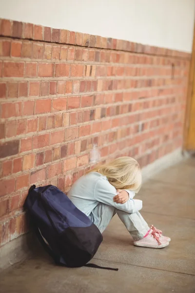 Sad pupil sitting alone on ground — Stock Photo, Image