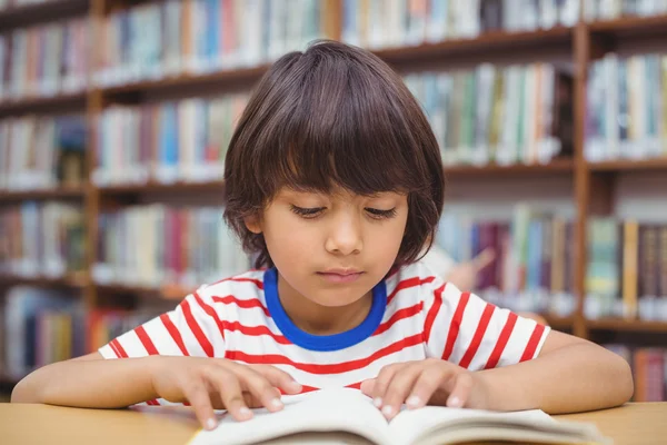 Aluno livro de leitura na mesa na biblioteca — Fotografia de Stock