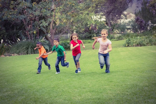 Bambini felici che corrono attraverso l'erba — Foto Stock