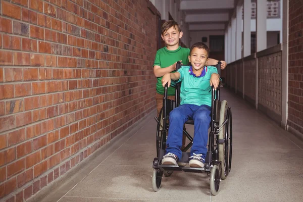 Studente sorridente in sedia a rotelle e amico accanto a lui — Foto Stock