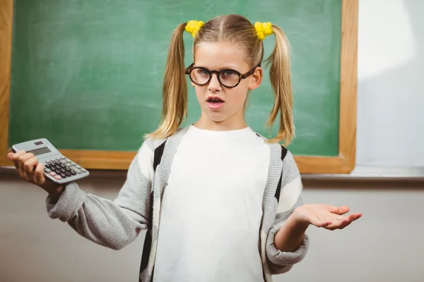 Verward schattig leerling bedrijf rekenmachine — Stockfoto