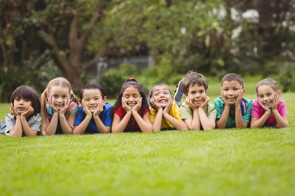 Schattig leerlingen liggen op het gras buiten — Stockfoto