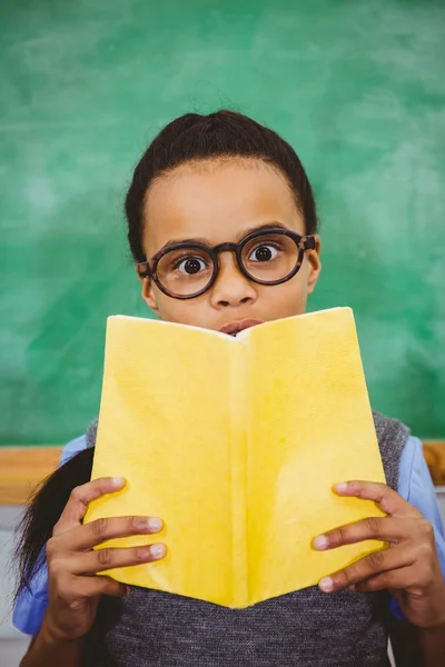 Alumno sorprendido sosteniendo libro escolar — Foto de Stock