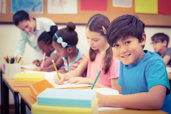 Leerlingen werken bij hun bureaus in de klas — Stockfoto