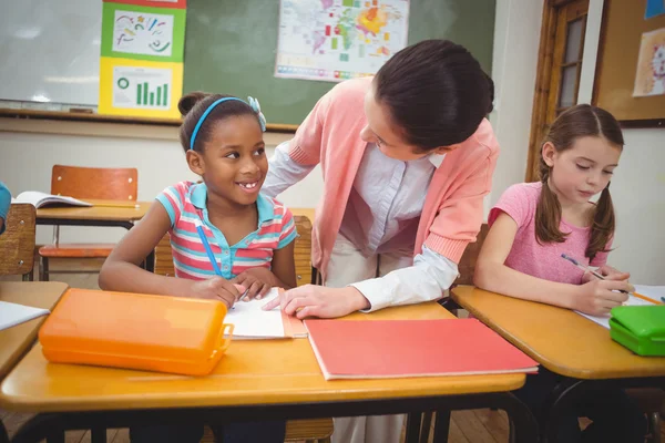 Pupil and teacher at desk in classroom — Stock Photo, Image