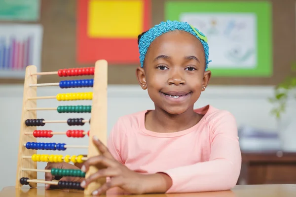 Leende elev beräkna med abacus i ett klassrum — Stockfoto