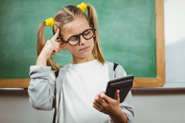 Schattig leerling berekening met rekenmachine in een klaslokaal — Stockfoto