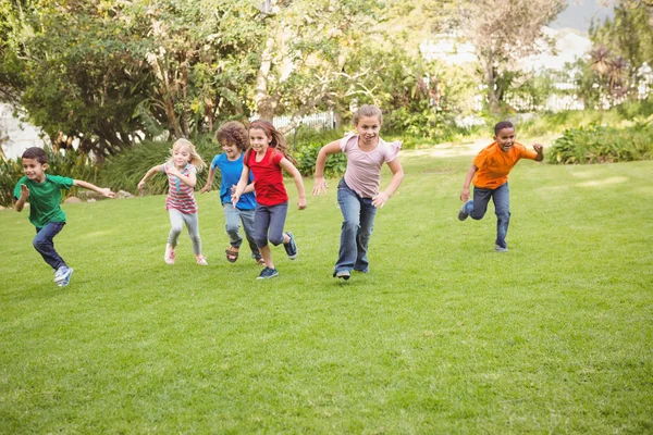 Crianças correndo na grama — Fotografia de Stock