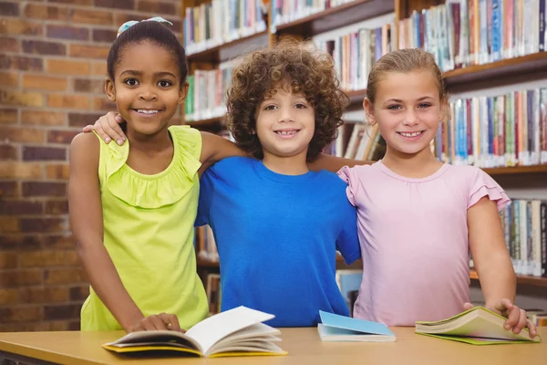 Zadowoleni uczniowie czytając książkę biblioteka — Zdjęcie stockowe