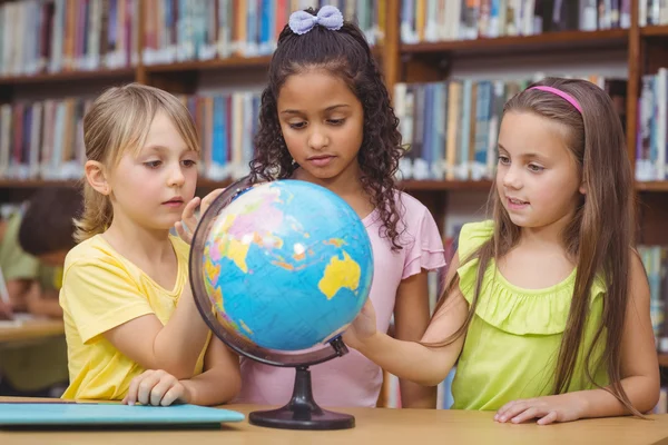 Leerlingen in bibliotheek met globe — Stockfoto