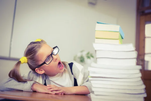 Elève regardant choqué par la pile de livres sur son bureau — Photo