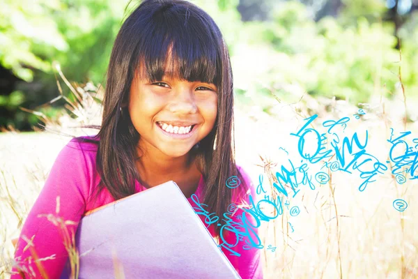 Cute little girl reading in park — Stock Photo, Image