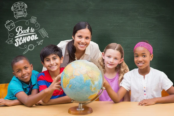 Cute pupils and teacher looking at globe — Stock Photo, Image
