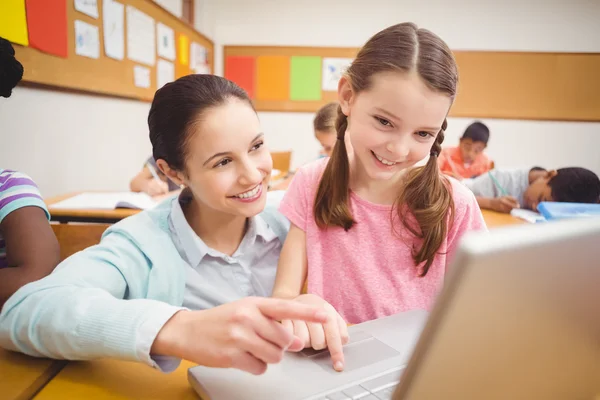 Teacher using laptop with pupil — Stock Photo, Image