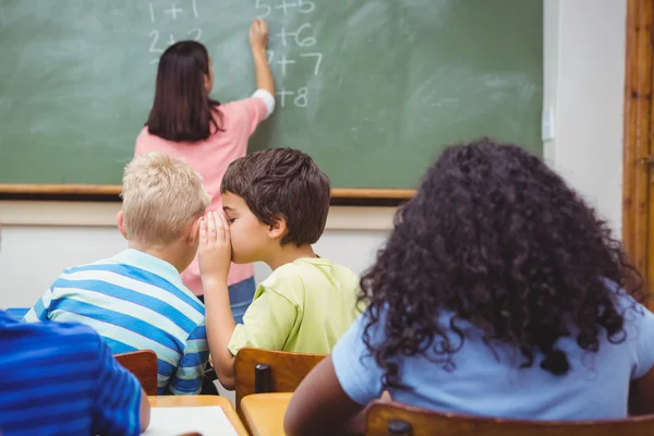 Student whispering into another students ear — Stock Photo, Image