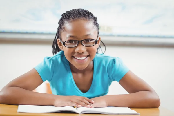 Smiling leerling leesboek in een klaslokaal — Stockfoto