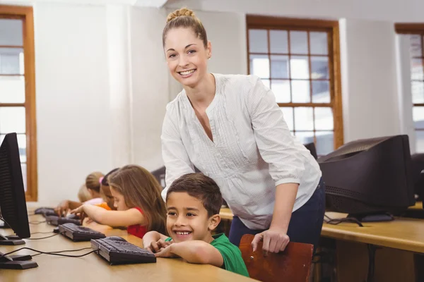 Profesor ayudando a un estudiante usando una computadora —  Fotos de Stock