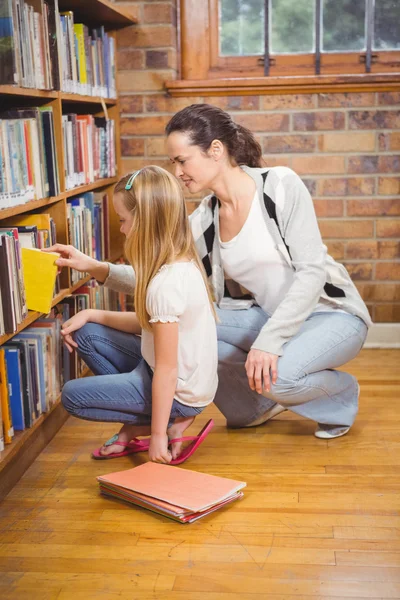 Profesor ayudando a estudiante a elegir un libro — Foto de Stock