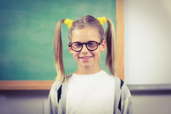 Cute pupil standing in front of chalkboard — Stock Photo, Image