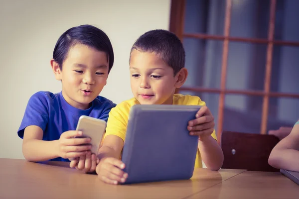 Nette Schüler im Unterricht mit Handy und Tablet — Stockfoto