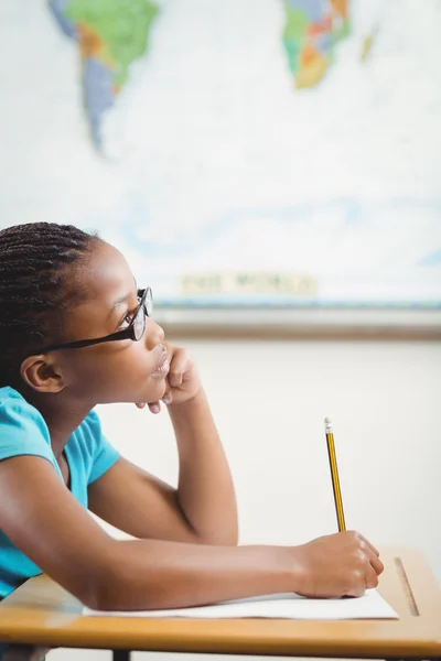 Сосредоточенная ученица работает за своим столом в классе — стоковое фото