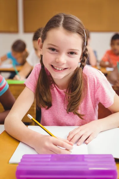 Ragazzina sorridente alla macchina fotografica in classe — Foto Stock