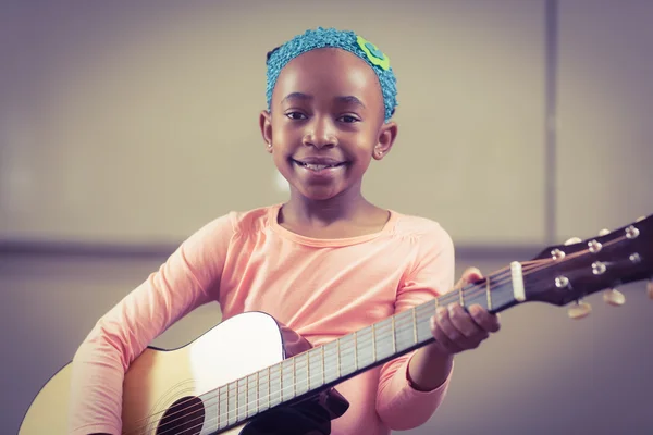 Lächelnder Schüler spielt Gitarre im Klassenzimmer — Stockfoto