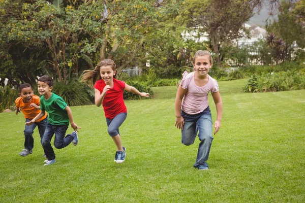 Bambini felici che corrono attraverso l'erba — Foto Stock