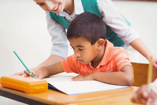 Enseignant aidant un petit garçon pendant la classe — Photo