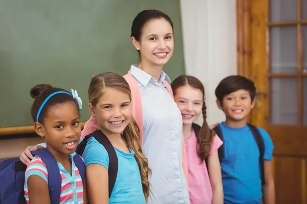 Professora e alunos sorrindo em sala de aula — Fotografia de Stock