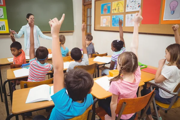 Öğrencilerin sınıf sırasında ellerini yükselterek — Stok fotoğraf