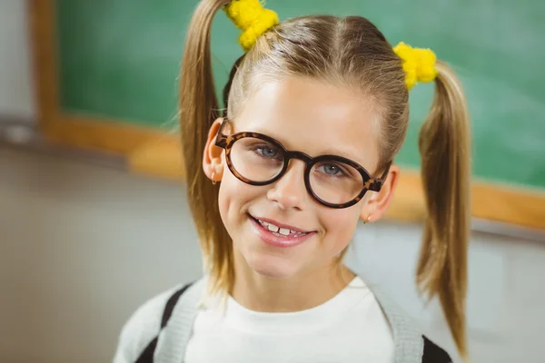 Schattig leerling lacht om de camera in een klaslokaal — Stockfoto