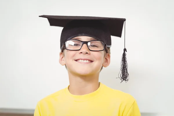 Smiling pupil with mortar board and glasses — Stock Photo, Image